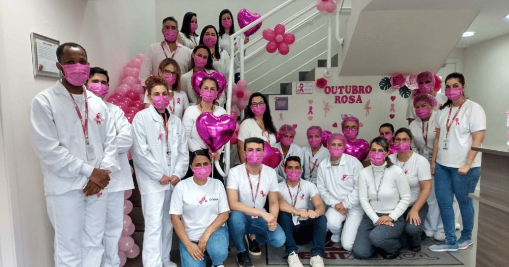 绩效团队的成员在巴西的照片穿着粉红色口罩,摆姿势乳腺癌意识照片